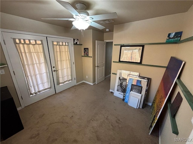 interior space featuring carpet, baseboards, visible vents, a ceiling fan, and french doors