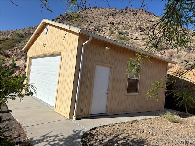 detached garage with a mountain view and concrete driveway