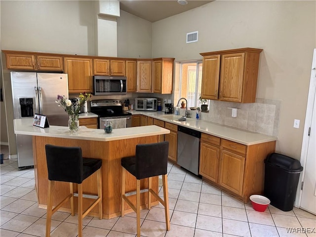 kitchen featuring stainless steel appliances, a sink, visible vents, a high ceiling, and light tile patterned flooring
