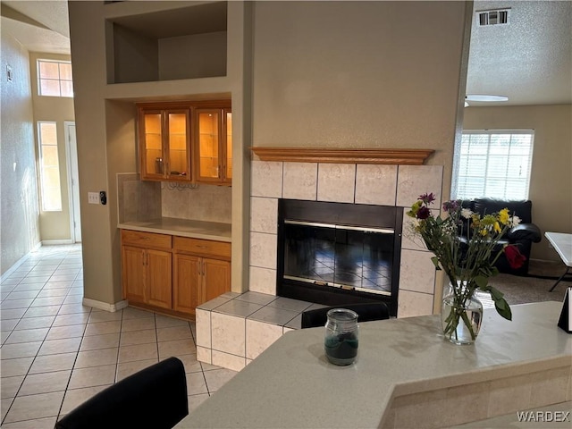 living room featuring baseboards, visible vents, light tile patterned floors, and a wealth of natural light