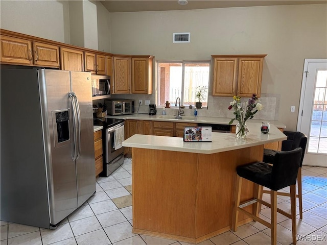 kitchen featuring a sink, visible vents, stainless steel appliances, light countertops, and light tile patterned flooring