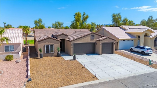 ranch-style house featuring a garage, a tile roof, driveway, and stucco siding