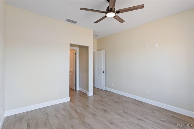 spare room with light wood-style floors, visible vents, baseboards, and ceiling fan