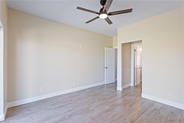 spare room with a ceiling fan, baseboards, and light wood finished floors