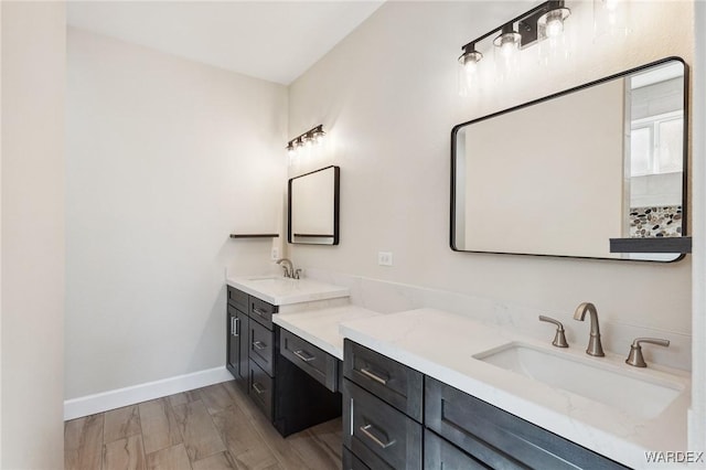 bathroom with baseboards, wood finished floors, and vanity