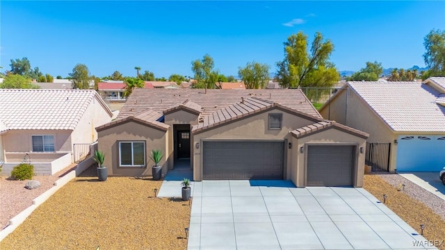 view of front facade featuring stucco siding, concrete driveway, fence, a garage, and a tiled roof