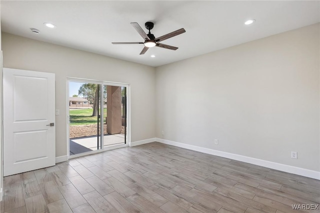 spare room with light wood finished floors, ceiling fan, and baseboards