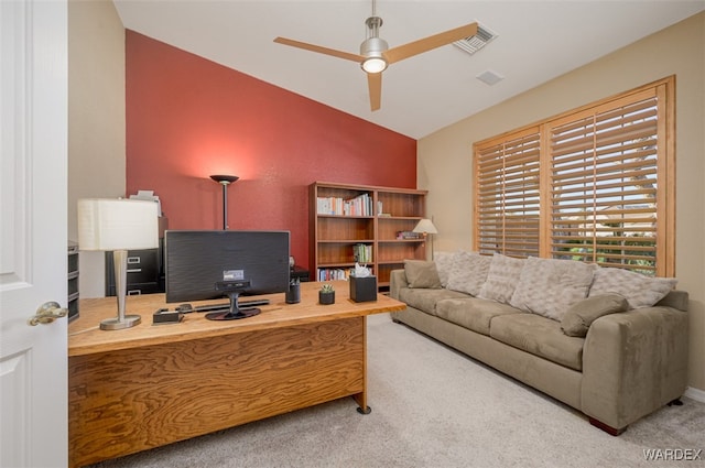 carpeted home office featuring a ceiling fan, lofted ceiling, and visible vents