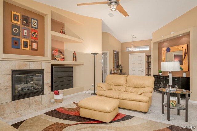 carpeted living area with baseboards, built in features, a ceiling fan, lofted ceiling, and a fireplace