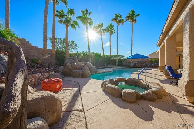 view of pool featuring a patio area, a fenced backyard, a fenced in pool, and an in ground hot tub