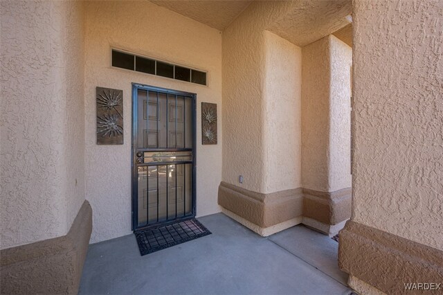 view of exterior entry with stucco siding