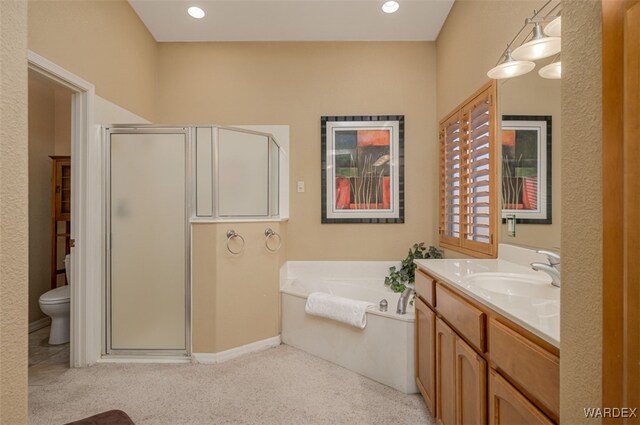 bathroom featuring recessed lighting, a garden tub, a shower stall, and vanity