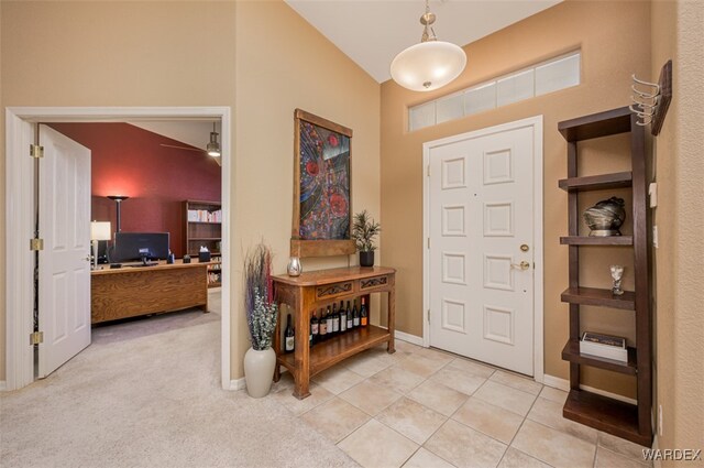 entryway with baseboards, light tile patterned floors, and light colored carpet