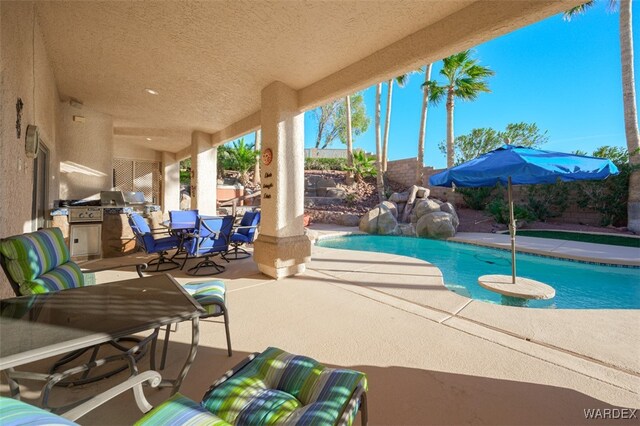 view of pool with a patio, outdoor dining area, an outdoor kitchen, a fenced backyard, and a fenced in pool