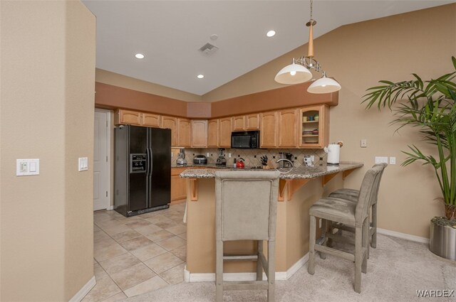 kitchen with visible vents, glass insert cabinets, a kitchen breakfast bar, a peninsula, and black appliances