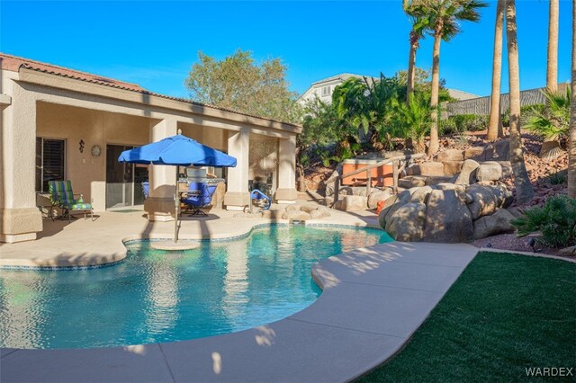 outdoor pool with a patio area and fence