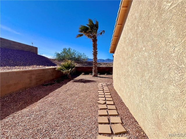 view of yard featuring fence and a mountain view