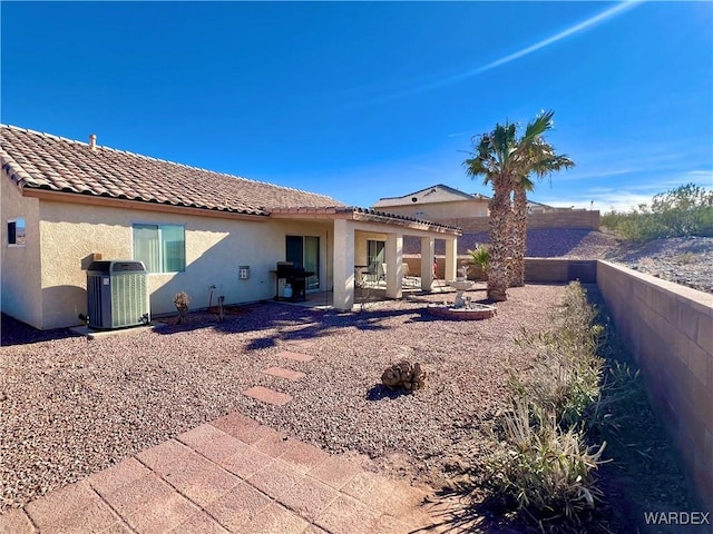 rear view of property with a patio area, cooling unit, a tile roof, and stucco siding