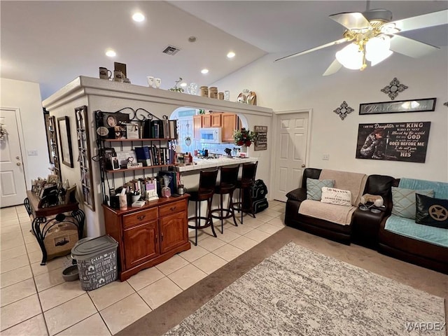 living area with recessed lighting, visible vents, a ceiling fan, light tile patterned flooring, and vaulted ceiling