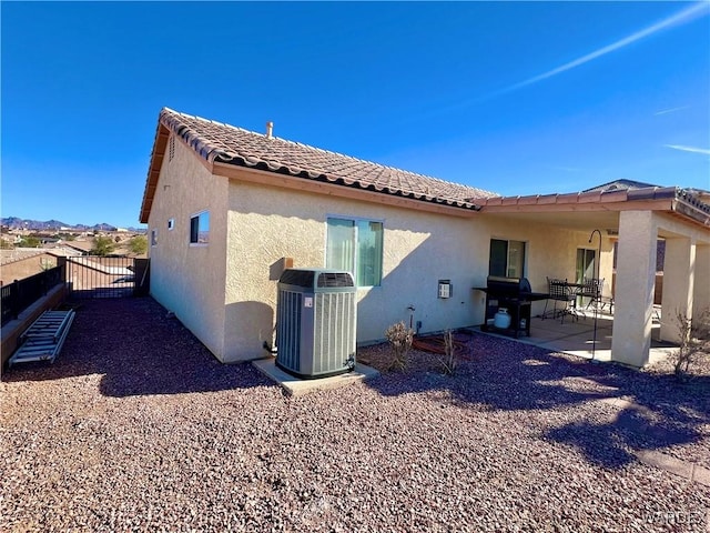 back of property featuring central AC, a patio area, fence, and stucco siding