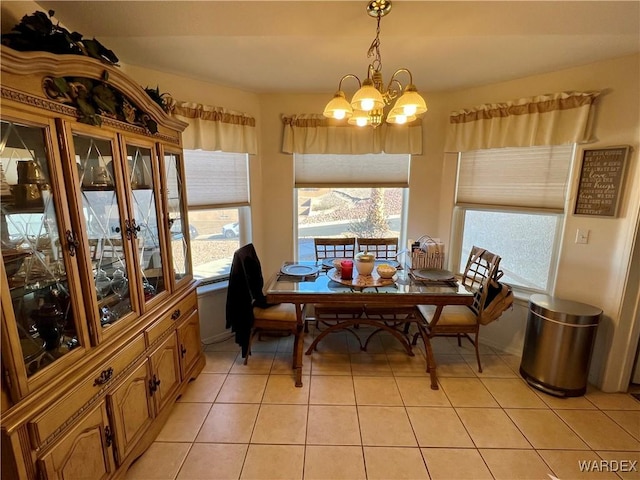 dining space featuring light tile patterned floors and a notable chandelier