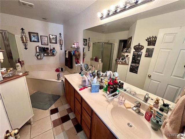 bathroom with double vanity, visible vents, a garden tub, a shower stall, and a sink