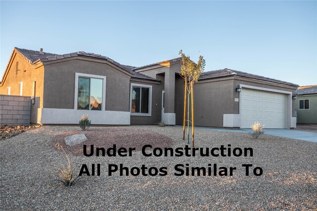 2950 E Colina Vis, Kingman, AZ 86409 - view of front of house featuring an attached garage, stucco siding, and concrete driveway