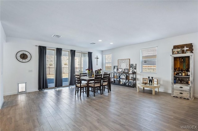 dining space with baseboards, visible vents, wood finished floors, and recessed lighting