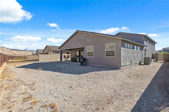 back of property featuring central AC, a patio area, a fenced backyard, and stucco siding