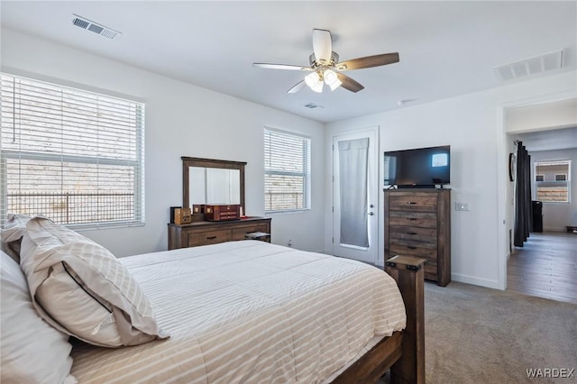 carpeted bedroom featuring baseboards, visible vents, and ceiling fan