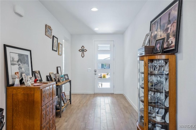 foyer entrance featuring light wood-style floors, recessed lighting, and baseboards