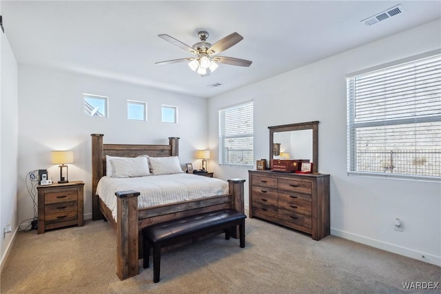 bedroom featuring baseboards, ceiling fan, visible vents, and light colored carpet