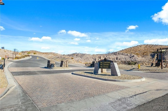 view of road featuring a mountain view and curbs