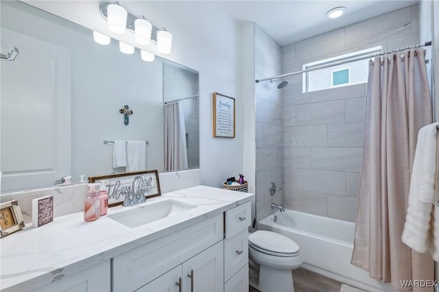 bathroom with toilet, wood finished floors, vanity, and shower / bathtub combination with curtain