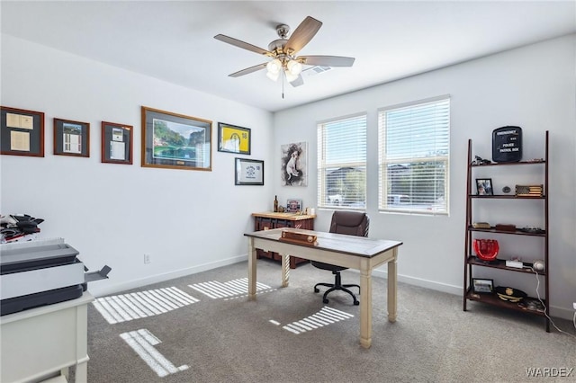 carpeted home office featuring a ceiling fan and baseboards