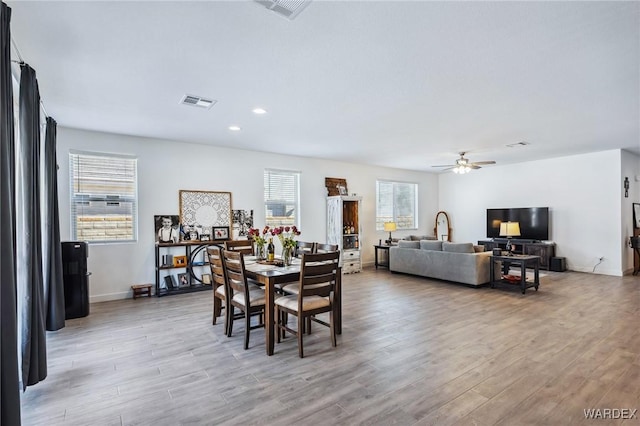 dining room with light wood-style flooring, visible vents, and ceiling fan