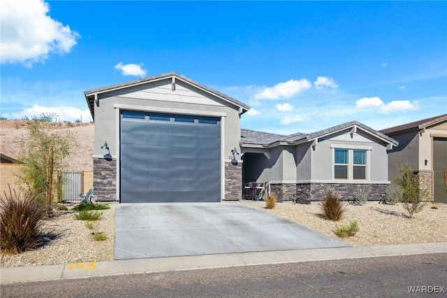 view of front of property featuring driveway, stone siding, an attached garage, fence, and stucco siding