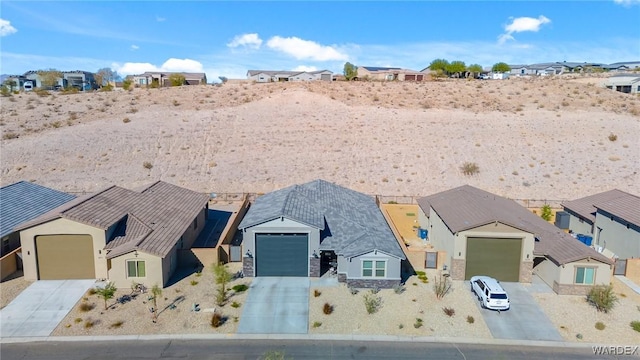 single story home with driveway, stone siding, a residential view, and stucco siding