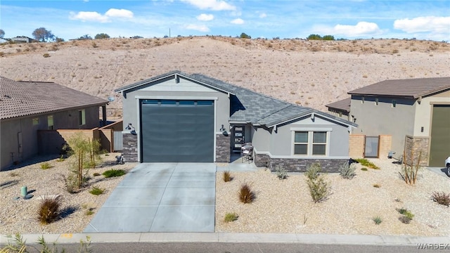 view of front of property with an attached garage, stone siding, concrete driveway, and stucco siding