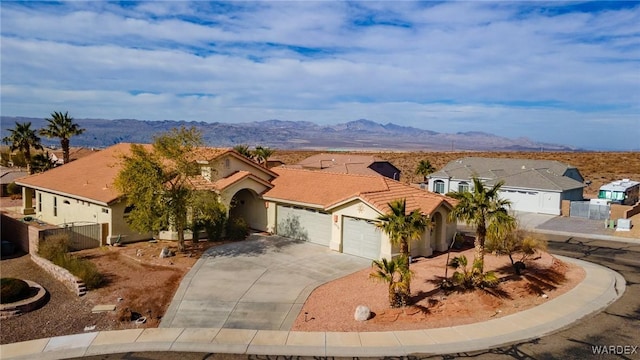 view of front of house featuring a garage, a residential view, a mountain view, and stucco siding