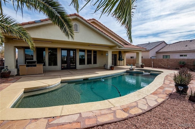 view of swimming pool featuring a fenced in pool, fence, an outdoor kitchen, and a patio