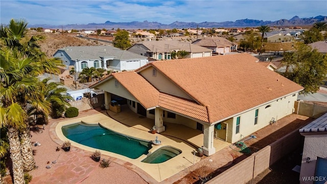 view of pool with a residential view, a patio area, a fenced backyard, and a mountain view