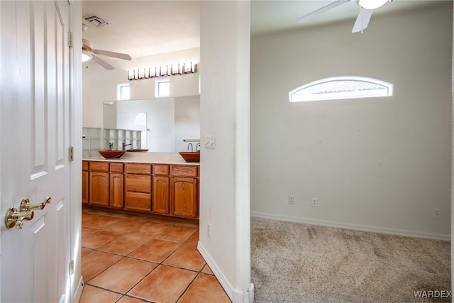 bathroom with double vanity, a sink, visible vents, and a ceiling fan