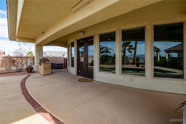 view of patio with french doors and fence