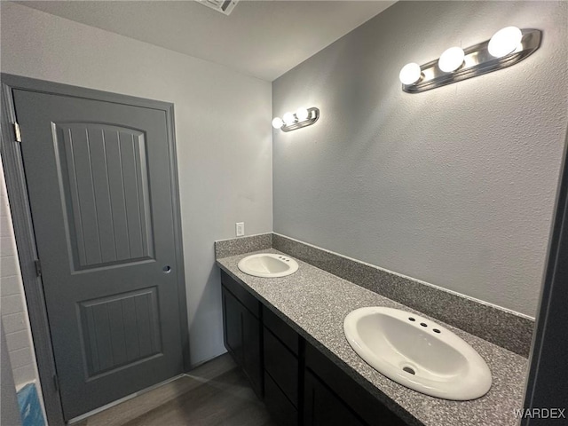 full bathroom with double vanity and a sink