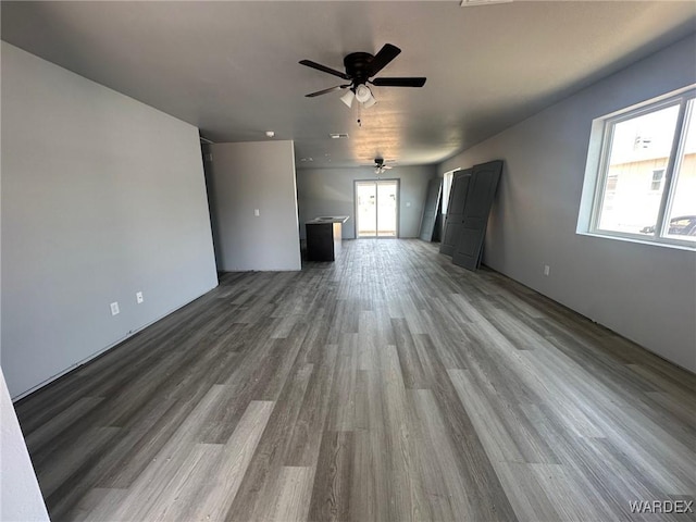 unfurnished living room with wood finished floors and a ceiling fan