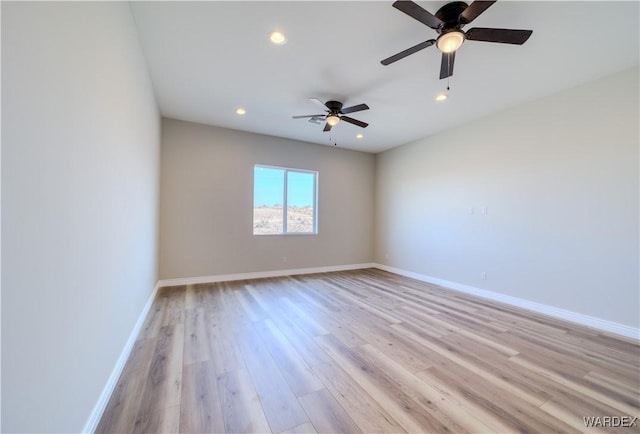 spare room featuring recessed lighting, light wood-type flooring, and baseboards