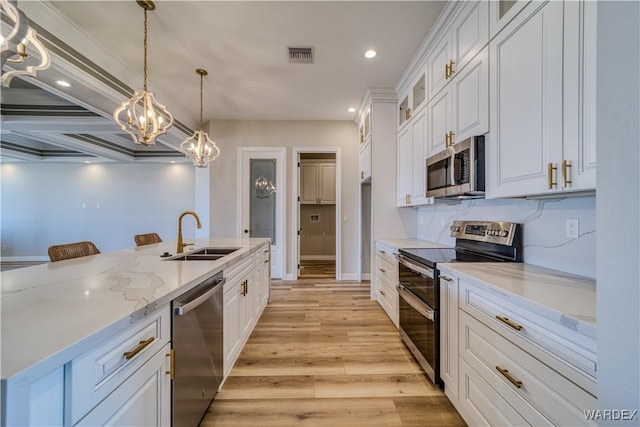 kitchen featuring visible vents, white cabinets, glass insert cabinets, decorative light fixtures, and stainless steel appliances