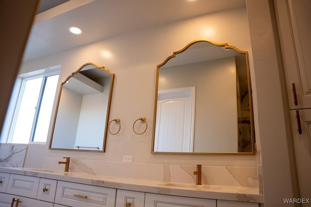 bathroom with recessed lighting, a sink, and double vanity