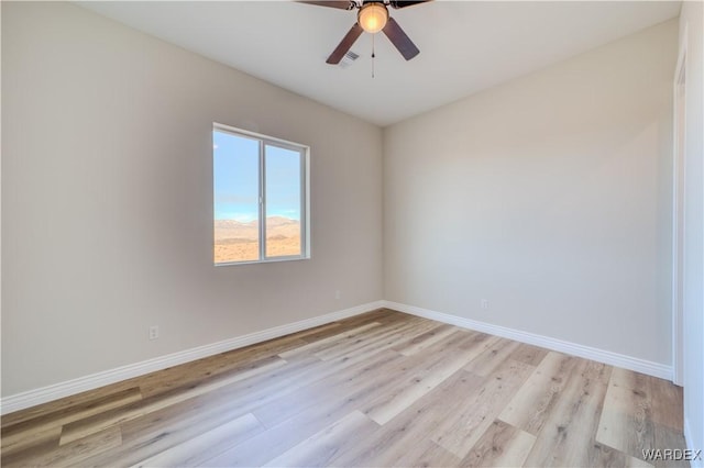 unfurnished room with visible vents, a ceiling fan, light wood-style flooring, and baseboards